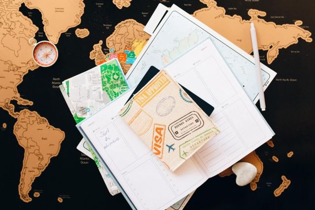 Travel visa and schedule planner stacked on desktop world map.
